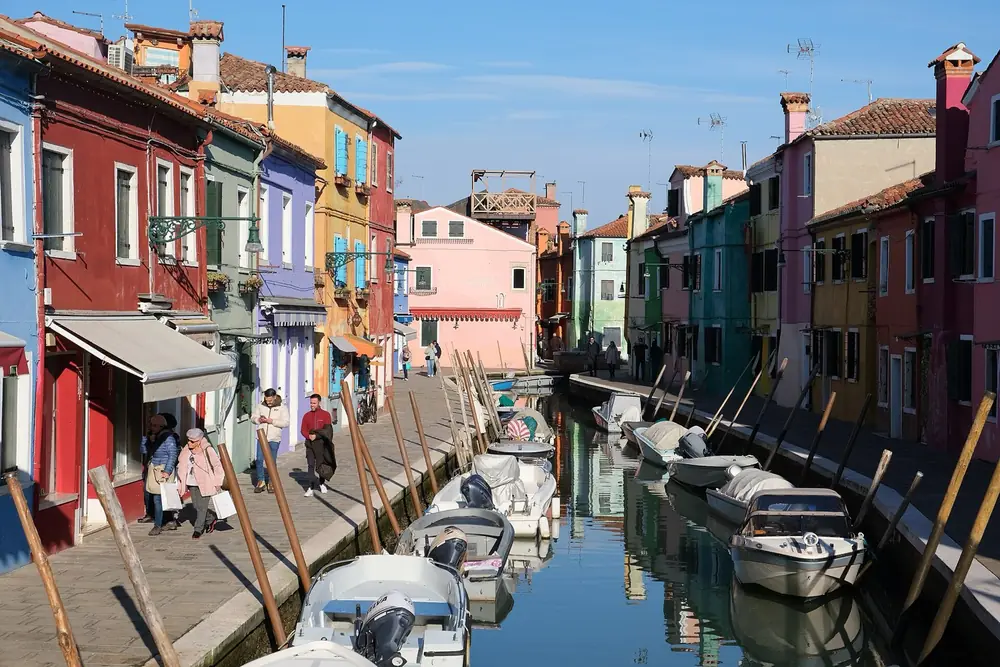 Painted houses and moored boats on a canal in Burano